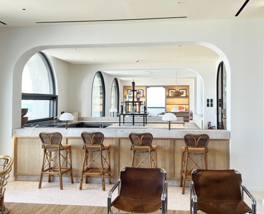 Bar des Voûtes : comptoir en pierre, façades cannées et tabourets en rotin – Île de Bendor, GH & Partners