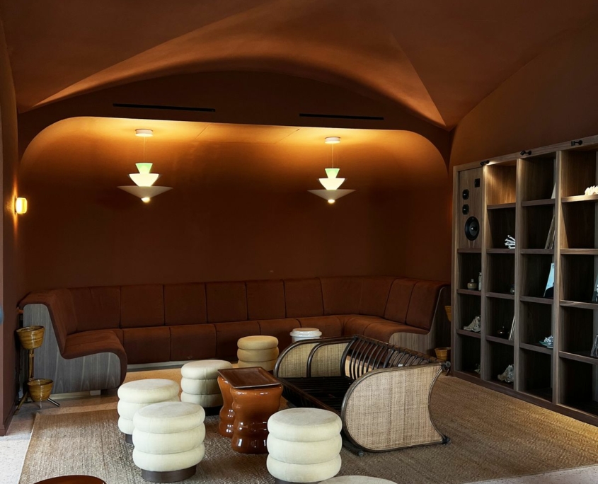Lounge aux murs voûtés terracotta avec banquette sur mesure – Île de Bendor, agencement GH & Partners